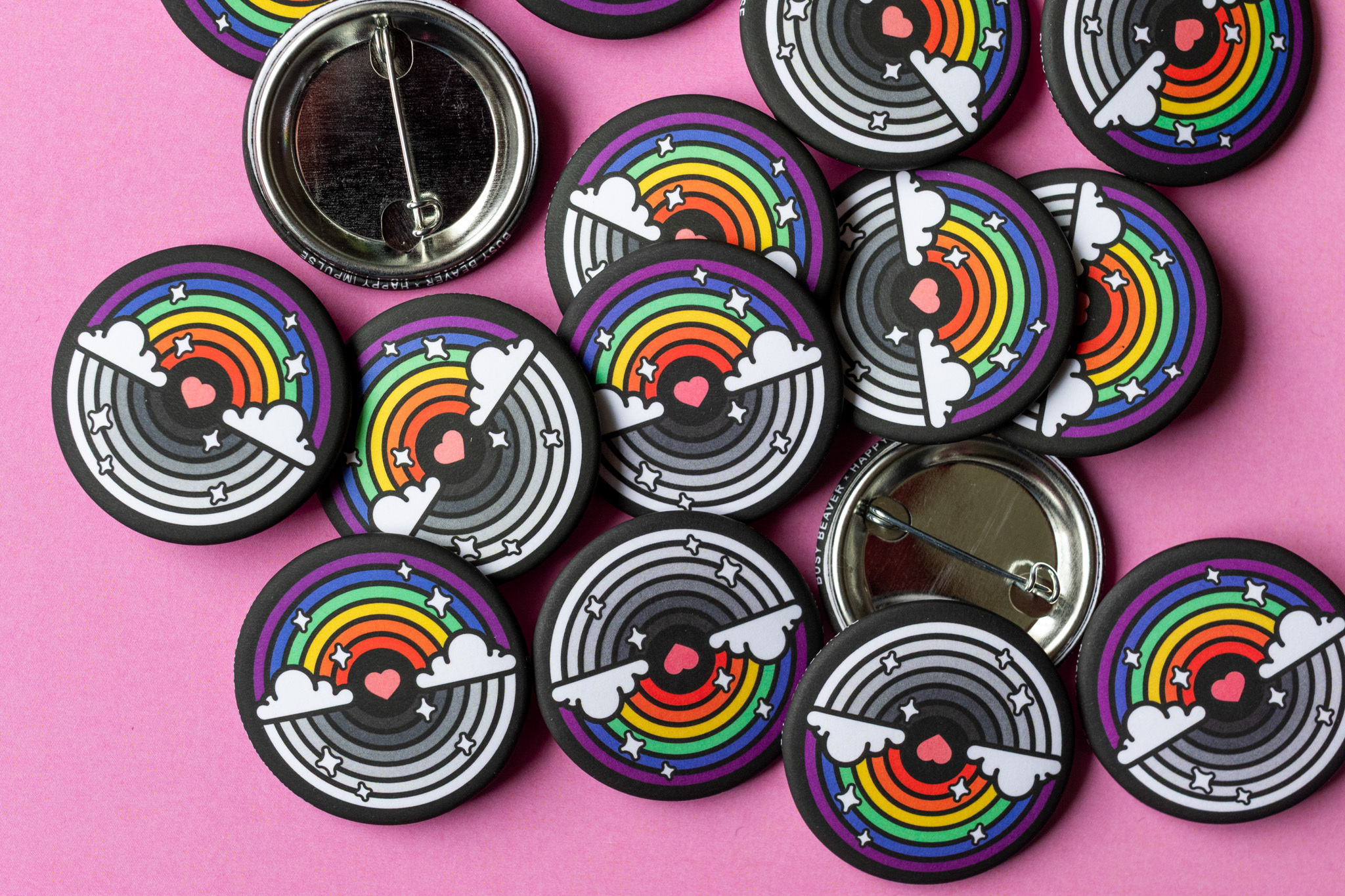 Busy Beaver x Happy Impulse Button rainbow pride buttons on pink background