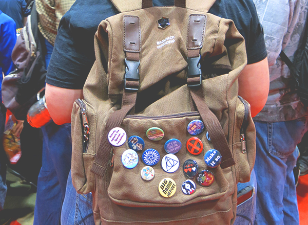 woman wearing comic con buttons on backpack