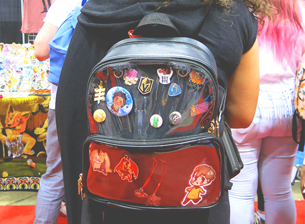 clear backpack displaying comic con buttons